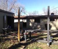 Mr. Money Mustache amongst his favorite elements (sunshine, tools, dirt), setting steel posts for a fancy fence.